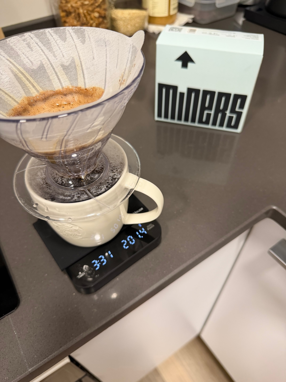 A pour-over brewing into a mug on a scale